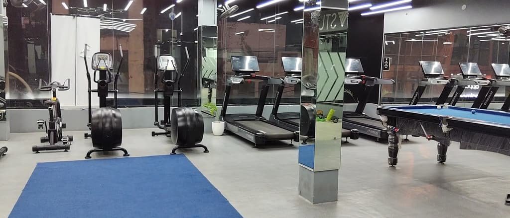 The cardio floor at Delta Fitness Gym with treadmills, cross trainers and a pool table